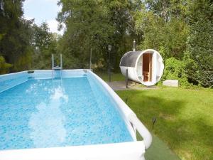 a large swimming pool with a boat in a yard at Large holiday home, summer pool, sauna, whirlpool in Sasino