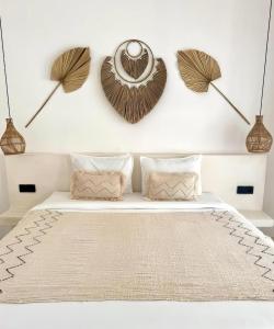 a bedroom with a white bed with two fans on the wall at Sola Rooms in Kuta Lombok +3 photos