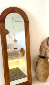 a mirror in a room with a vase at Sola Rooms in Kuta Lombok
