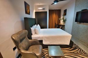 a hotel room with a bed and a tv at Newport Hotel in Atimpoko