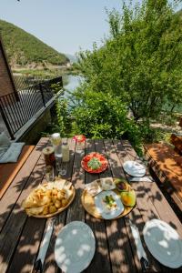a wooden table with plates of food on top of it at Borealis Guest House in Koman