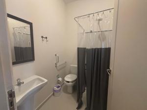a bathroom with a shower curtain and a toilet at Mini Studio Villaggio juquehy in São Sebastião