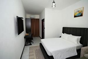 a small bedroom with a bed and a chair at Newport Hotel in Atimpoko +93 photos