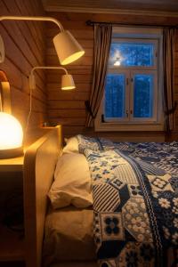 a bedroom with a bed with a lamp and a window at Private archipelago villa with large property in Pargas