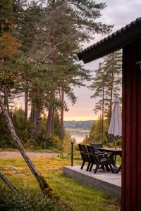 a picnic table and chairs on a deck with a view of a lake at Private archipelago villa with large property in Pargas +30 photos