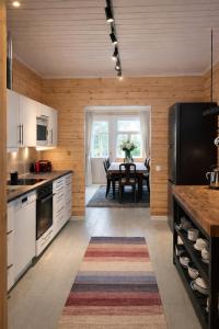 a kitchen with a table and a black refrigerator at Private archipelago villa with large property in Pargas