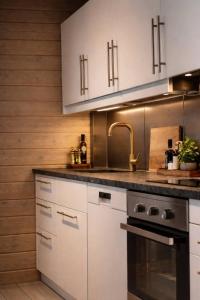 a kitchen with white cabinets and a sink at Private archipelago villa with large property in Pargas