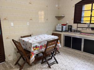 a kitchen with a table and chairs in a kitchen at Pousada Jardim Alterosa in Vespasiano