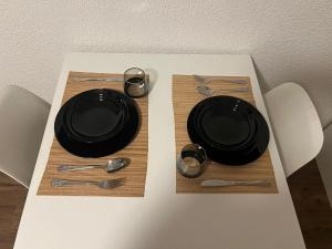 a table with black plates and utensils on it at Central Living Brugg - Studio 11 in Brugg