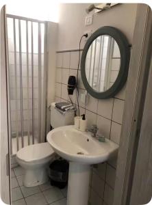 a bathroom with a sink and a mirror and a toilet at DAREB HOME vista mare in Agrigento