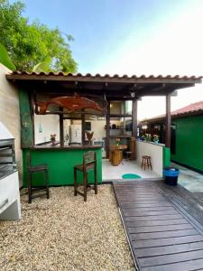 a patio with an outdoor bar with an umbrella at Hospedaria aconchego master in Garopaba