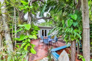 a patio with a table and chairs and trees at Garden botanical Villa with jacuzzi in Hollywood