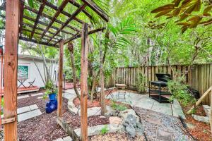 a backyard with a wooden pergola and a bench at Garden botanical Villa with jacuzzi in Hollywood