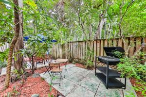 a patio with a table and chairs and a grill at Garden botanical Villa with jacuzzi in Hollywood