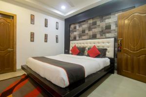 a bedroom with a large bed with red pillows at Hotel OThe Blu Bell in Guwahati