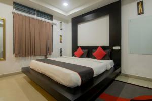 a bedroom with a large bed with red pillows at Hotel OThe Blu Bell in Guwahati