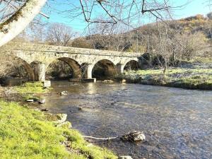 a bridge over a river with ducks in the water at gite du navech in Camjac