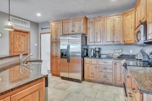 a kitchen with wooden cabinets and a stainless steel refrigerator at Bridges Bay Resort Coronado Building 302 in Arnolds Park