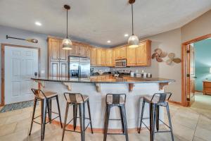 a kitchen with wooden cabinets and bar stools at Bridges Bay Resort Coronado Building 302 in Arnolds Park