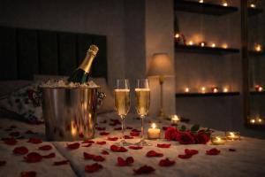 a bottle of champagne and two glasses on a table with roses at Italian House Bieszczady in Bachlowa +12 photos