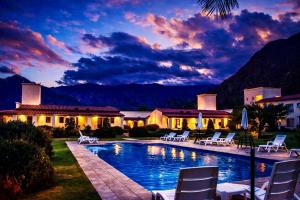 a villa with a swimming pool at dusk at Viñas De Cafayate Wine Resort in Cafayate