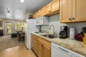a kitchen with a sink and a white refrigerator at WorldMark Grand Lake in Monkey Island