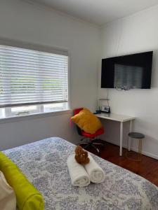 a bedroom with a bed with a teddy bear on a towel at Irina's bnb in Auckland