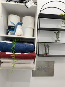 a closet with a bunch of towels and plates at Irina's bnb in Auckland