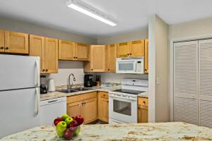 a kitchen with white appliances and a bowl of fruit at WorldMark Grand Lake in Monkey Island +29 photos