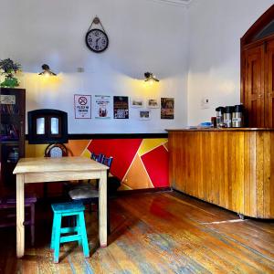 a table and stool in a room with a clock on the wall at Econunay Hostels in Arequipa