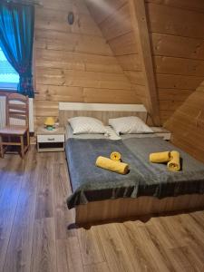a bedroom with a bed with two yellow objects on it at Miodowa Chatka in Brzegi