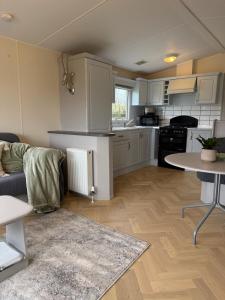 eine Küche und ein Wohnzimmer mit Sofa und Tisch in der Unterkunft Eastington in Lapford