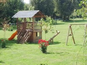 a playground with a wooden play house and a slide at Regreso al Encanto in Puyehue