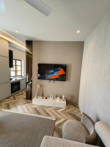 a living room with a tv on a wall at Old Town Suites Muradie in Vlorë