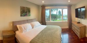 a bedroom with a large bed and a window at Large ocean view family retreat in Comox +23 photos
