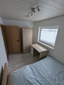 a bedroom with a bed and a desk and a window at Apartment Kraft in Aßlar