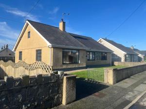 a house with a stone fence in front of it at Morannedd in Pwllheli