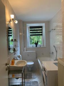 a bathroom with a sink and a toilet and a tub at moderne Ferienwohnung Nähe Goitzschesee in Greppin
