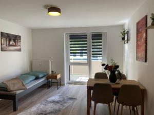 a living room with a table and a bed and a dining room at moderne Ferienwohnung Nähe Goitzschesee in Greppin