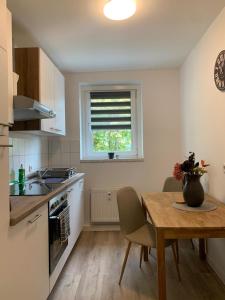 a kitchen with a table and a window and a table and chairs at moderne Ferienwohnung Nähe Goitzschesee in Greppin