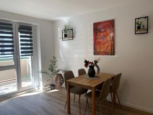 a dining room table with chairs and a vase on it at moderne Ferienwohnung Nähe Goitzschesee in Greppin +2 photos