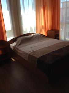 a bed sitting in a room with windows at Guest House SNG in Nesebar