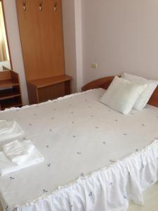 ein Bett mit weißer Bettwäsche und blauen Sternen darauf in der Unterkunft Guest House SNG in Nessebar