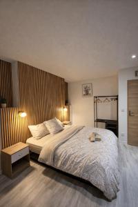 a bedroom with a large bed and a wooden wall at Tiny House Marie in Châtellerault