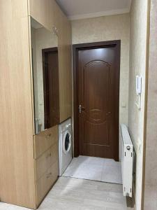a bathroom with a brown door and a washing machine at City View Apartments At Dadiani St in Tbilisi City
