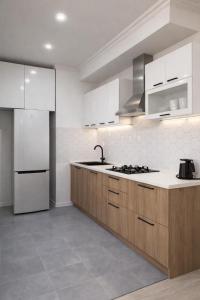 a kitchen with white appliances and wooden cabinets at City View Apartments At Dadiani St in Tbilisi City