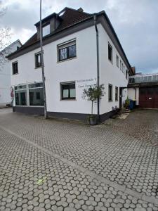 a white building with a tree in front of it at CUBE 5 New in Bad Saulgau