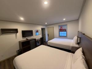 a hotel room with two beds and a flat screen tv at Travelodge by Wyndham Bainbridge in Bainbridge