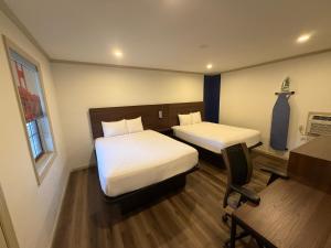 a small room with two beds and a desk and a desk at Travelodge by Wyndham Bainbridge in Bainbridge +2 photos
