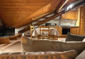 a living room with a table and a kitchen at Casa Mezzavalle in Pelugo